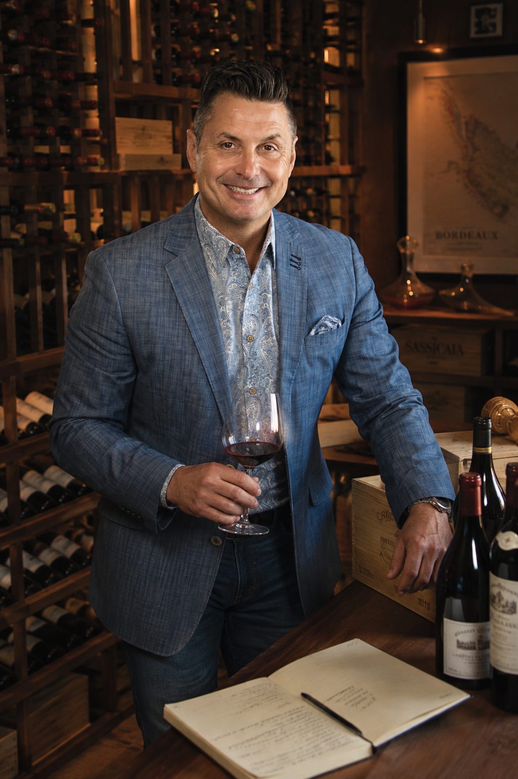 Éric Bigras, founder of iQWine, in his cellar, a glass of wine in hand.